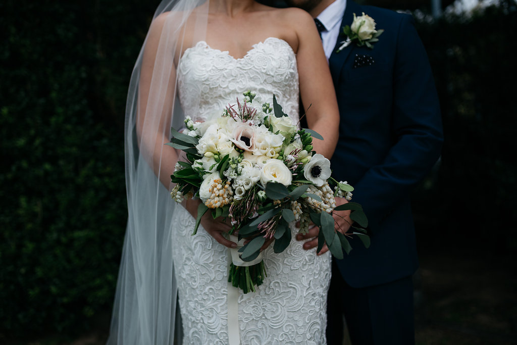 stylish luxury countryside wedding portraits of bride and groom  focused on bouquet